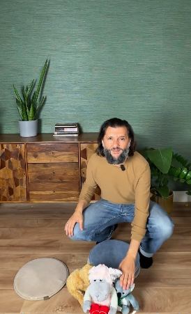 Balázs leguggolva rendezi a bábokat a szőnyegen
